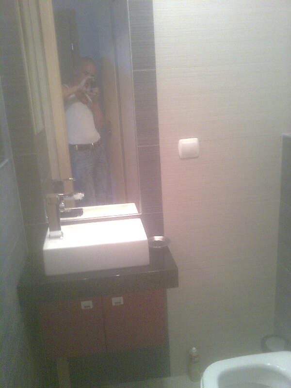 Nowoczesna umywalka nablatowa w łazience po remoncie w Szczecinie, widoczny odblask fotografa w lustrze.